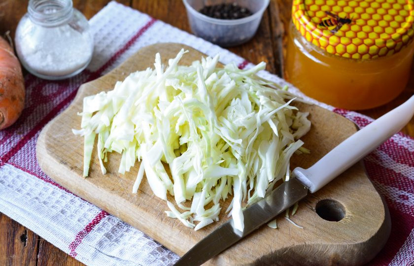 1. Этап. Капуста квашеная с медом: Нашинкуйте капусту тонкими полосками.