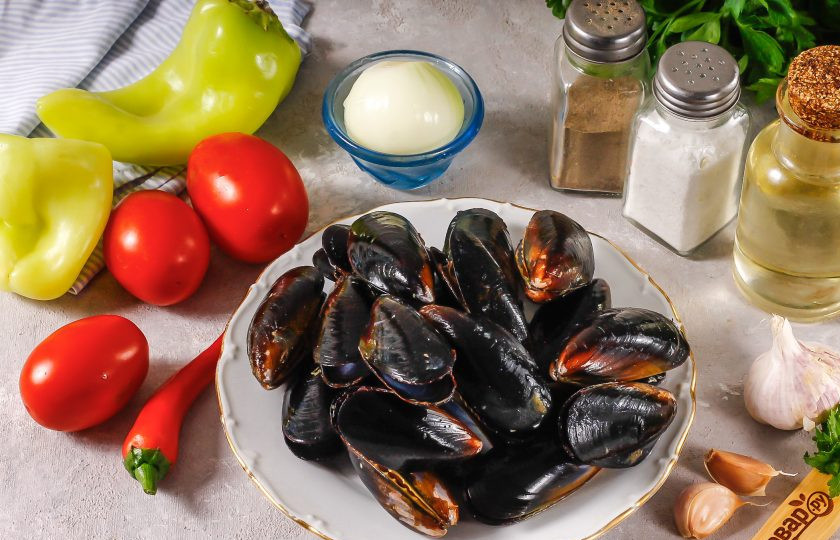 1. Этап. Мидии по-испански: Подготовьте указанные ингредиенты. Очистите зубчик чеснока и лук от шелухи, промойте в воде. Очистите болгарские перцы от семян, промойте вместе с томатами.