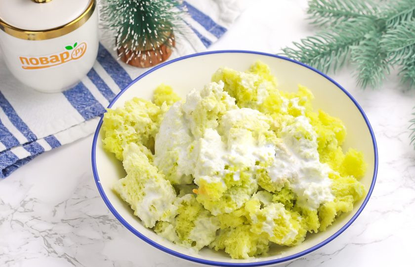 1. Этап. Торт Змейка на Новый год: Половину кондитерских сливок влейте в зеленую часть бисквита и тщательно перемешайте.