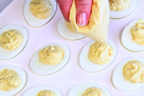 1. Этап. Яйца с пряностями II: Смесь тщательно перемешайте и переложите в кондитерский мешок. Затем наполните пряной начинкой углубления в половинках белков.