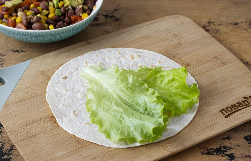 1. Этап. Бурито с кукурузой: Лепешку подогрейте на сухой сковороде с двух сторон. Выложите на лепешку салатный лист.