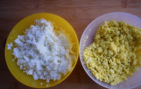 1. Этап. Салат Нежность с курицей и черносливом: Желтки отделите от белков. Желтки измельчите вилкой, а белки натрите на терке.