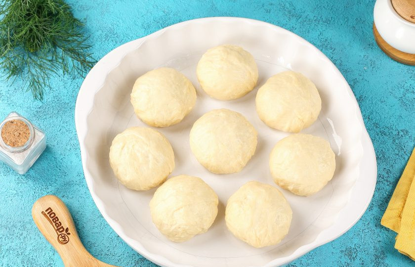 1. Этап. Пампушки с чесноком к борщу: Сформируйте из теста одинакового размера шарики, у меня получилось 8 штук по 100 грамм. Выложите их в смазанную маслом форму на некотором расстоянии друг от друга.