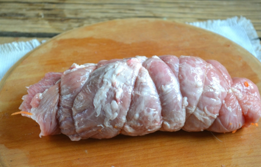 1. Этап. Новогодний рулет из свинины: Сверните мясо в рулет и туго обмотайте нитью, чтобы держал форму. Это очень важно, если хотите получить идеальный закусочный рулетик.