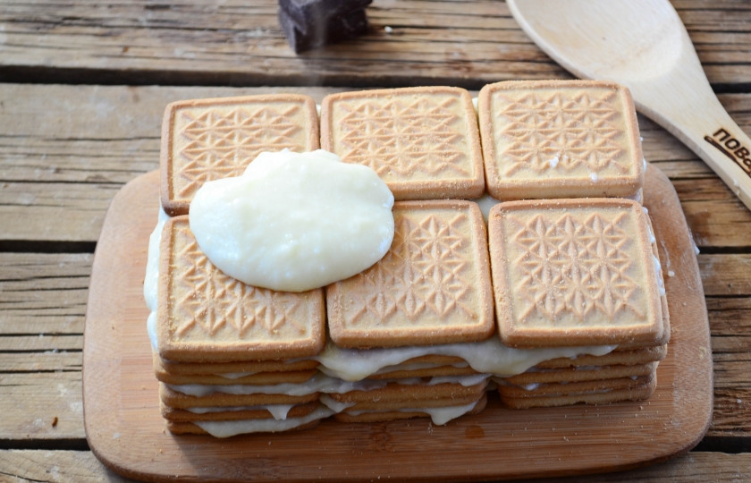 1. Этап. Торт из печенья с заварным кремом: Снова накройте печеньем и смажьте кремом. Так продолжайте со всем остальным печеньем. Готовый торт сверху и по бокам смажьте остатками крема. Сверху присыпьте тертым шоколадом.