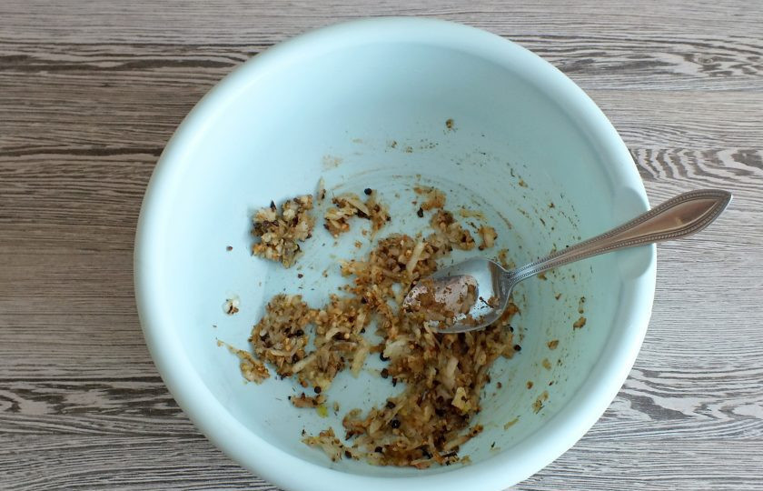 1. Этап. Буженина в вине: Возьмите просторную чашу. Натрите в неё на крупной терке луковицу и измельченный чеснок. Добавьте острый красный перец, хмели-сунели, кориандр, черный перец горошком. Перемешайте.