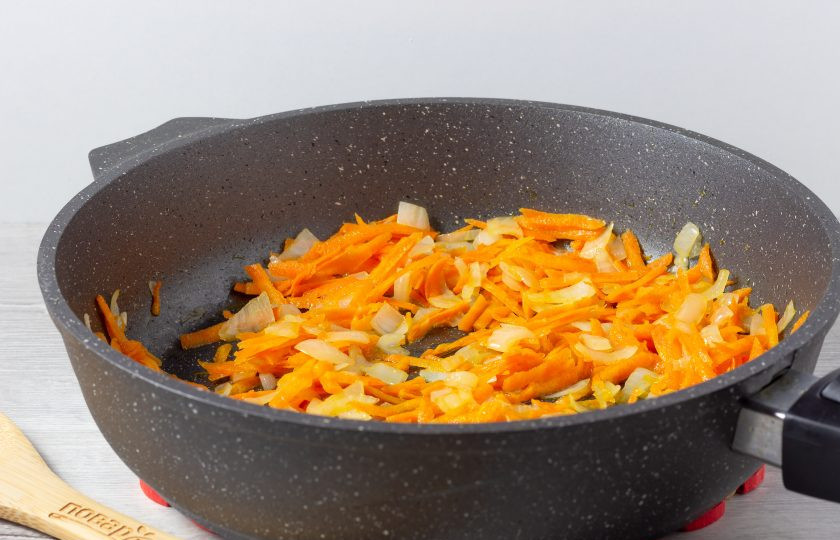 1. Этап. Поджарка из колбасы: На сковороде разогрейте растительное масло. Обжарьте мелко нарезанный лук, затем добавьте натертую на крупной терке морковь. Жарьте 2-3 минуты помешивая.