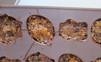 1. Этап. Сухофрукты в шоколаде: Если вы хотите, чтобы конфеты были с небольшой кислинкой, то в получившуюся массу можно добавить сок лимона. Смазываем силиконовые формочки слоем растопленного шоколада, отправляем в морозилку на 4 минуты, то же проделываем еще раз или два. Затем достаем формочки и выкладываем туда фруктовую начинку, утрамбовывая.