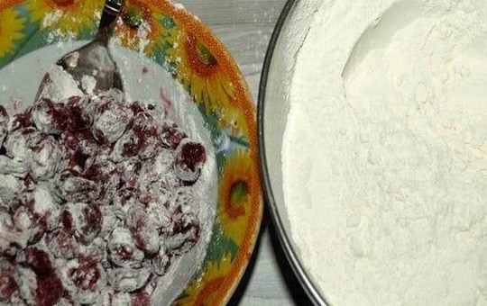 1. Этап. Вишневый пирог с кленовым сиропом: Заранее разморозьте вишню и дайте стечь лишней жидкости. Пшеничную муку просейте вместе с разрыхлителем, добавьте соль и перемешайте сухие ингредиенты. В подготовленную вишню добавьте 2 ст. л. мучной смеси и перемешайте.