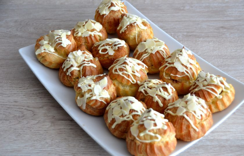 1. Этап. Профитроли с масляным кремом: Половину профитролей полейте белым растопленным шоколадом и посыпьте миндальными лепестками.