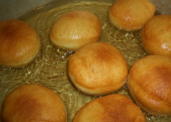 1. Этап. Пончики на простокваше: 7. В сковородке с высокими бортами разогрейте растительное масло. Опустите пончики в хорошо разогретое масло. Обжаривайте их на среднем огне с каждой стороны до появления румяного цвета.