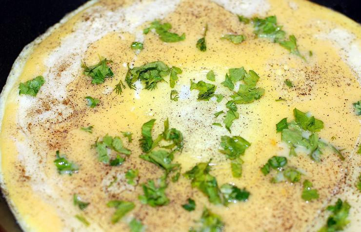 1. Этап. Омлет с помидорами и сыром: Когда нижняя сторона омлета загустеет, посыпаем его перцем и измельченной зеленью.