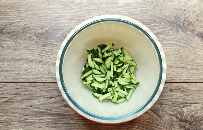 1. Этап. Постный салат с кукурузой: Огурцы порежьте соломкой и добавьте в салатник.