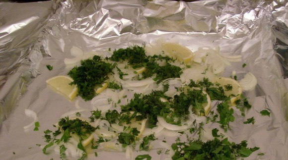 1. Этап. Стерлядь в фольге в духовке: Фольгу смажьте маслом. Выложите немного зелени, лук и лимона.