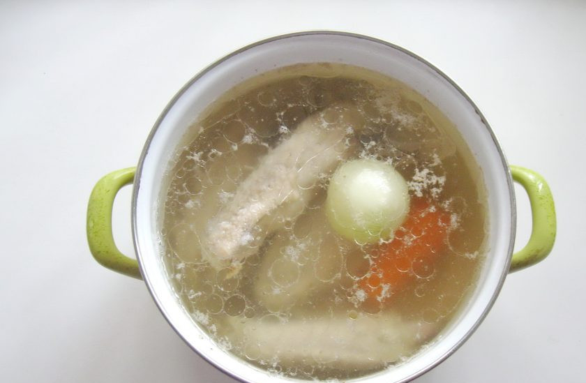 1. Этап. Заливное из индейки: Крылья индейки помойте и выложите в кастрюлю. Залейте водой. Доведите до кипения, снимите пену. Огонь уменьшите до минимума. Добавьте морковь и лук.