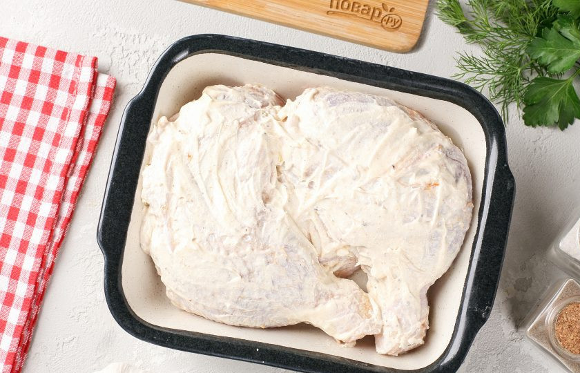 1. Этап. Куриные ножки со сметаной и сыром: Смажьте курицу со всех сторон сметаной и переложите в смазанную маслом форму для запекания.