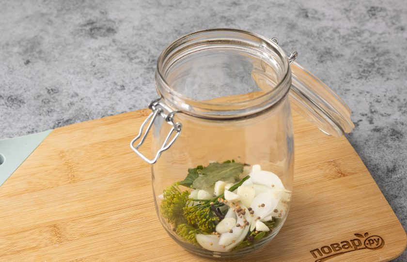 1. Этап. Черные помидоры в банках на зиму: В чистую стерилизованную банку выложите лист хрена, зонтик укропа, очищенный зубчик чеснока, лавровый лист, нарезанный перьями репчатый лук и все специи.