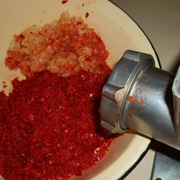 1. Этап. Аджика с орехами: Через мясорубку пропускаем острые перцы и очищенный чеснок. То же самое делаем с орехами и свежей кинзой.