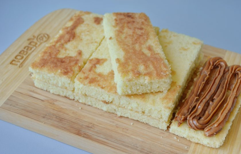 1. Этап. Кокосовые пирожные со сгущенкой: 9. Вареную сгущенку переложите в кондитерский мешок, поставьте насадку с большим отверстием (у меня звездочка). Переслоите бисквитики сгущенкой.