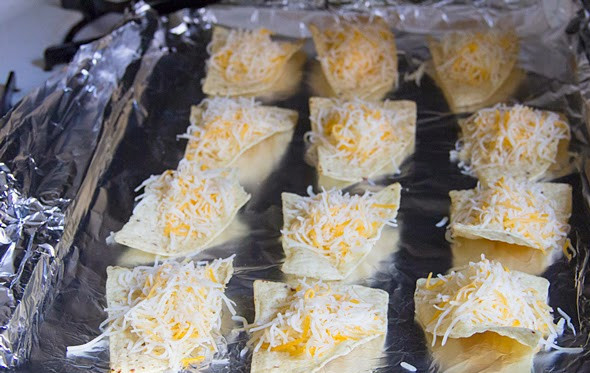 1. Этап. Канапе с чипсами: 2. Тушим все вместе под крышкой, пока соус не уварится. Тем временем чипсы раскладываем на противень, застеленный фольгой. На каждый кусочек помещаем ложку-другую тертого сыра.