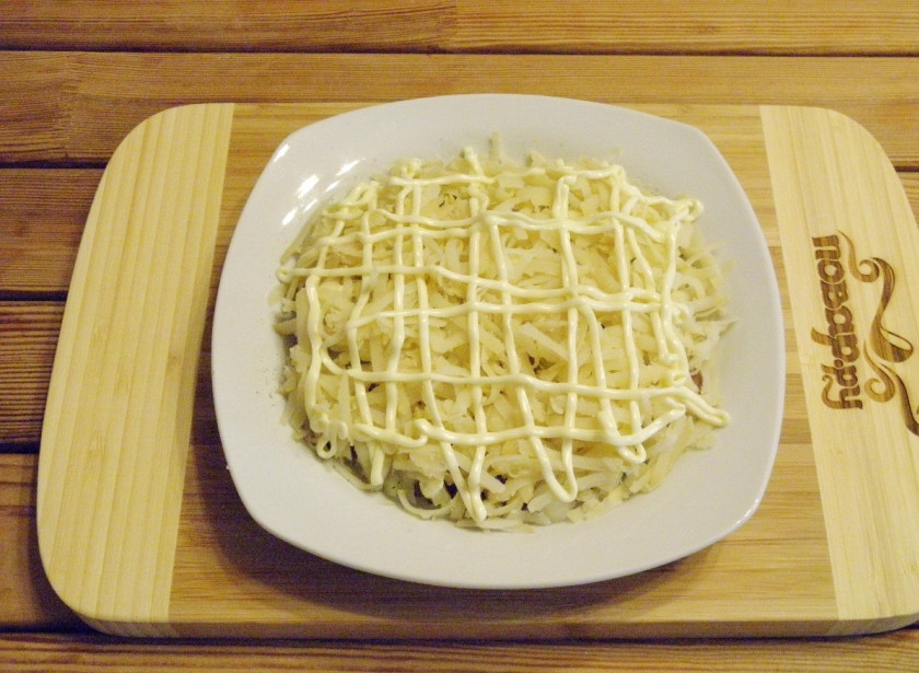 1. Этап. Селедка под шубой без яиц: Далее выложите на селедку слой картофеля, соль-перец — и снова майонезная сеточка.