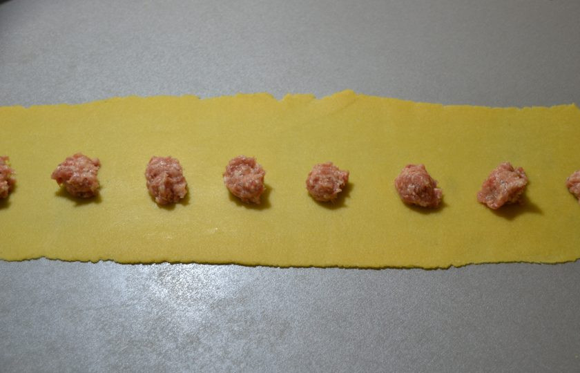 1. Этап. Аньолотти: Кусочек теста раскатайте очень тонко в ленту, на которую с интервалом 1,5-2 сантиметра выложите фарш.