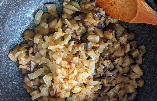 1. Этап. Необычная закуска из баклажанов с сыром: Добавляем к баклажанам жареный лук, перемешиваем.
