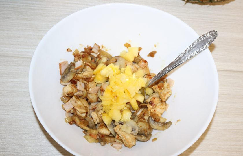 1. Этап. Фаршированные ананасы: Часть серцевинки ананаса нарежьте мелкими кубиками. Добавьте к обжаренному куриному филе и шампиньонам.