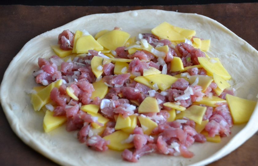 1. Этап. Лезгинский пирог с мясом и картофелем: Выложите раскатанный пласт теста на лист для выпечки, сверху выложите 1/3 часть начинки.
