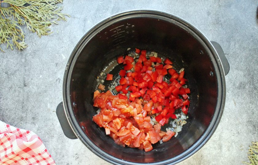 1. Этап. Суп гуляш в мультиварке: Болгарский перец и помидоры порежьте кубиком, выложите в мультиварку. Обжаривайте овощи еще 3 минуты.