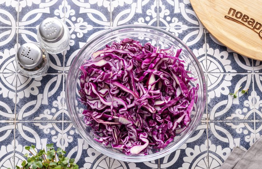 1. Этап. Салат из красной капусты с яблоками и арахисом: Красную капусту тонко нашинкуйте. Подсолите и пожмите руками, чтобы она стала мягче и дала сок.