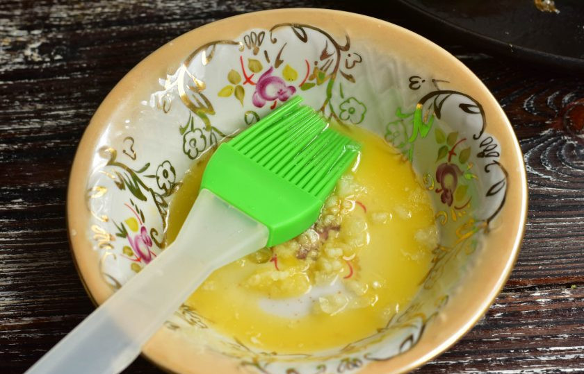 1. Этап. Пампушки с сыром: Растопите сливочное масло, выдавите к нему чеснок. Перемешайте.