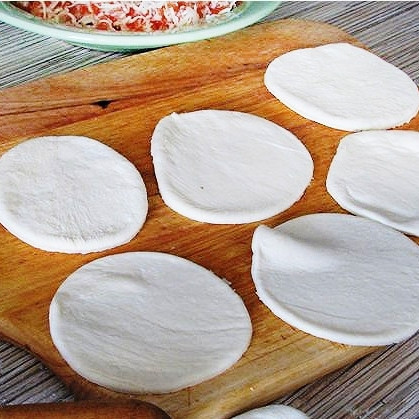 1. Этап. Пирожки с сёмгой: Слоеное тесто раскатываем в тонкий пласт, из которого при помощи большой чашки или бокала вырезаем кружочки.