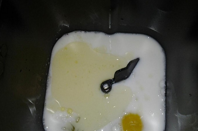 1. Этап. Хлеб на ряженке: 1. Сначала в чашу хлебопечки добавим все жидкие компоненты: яйцо, воду, масло и ряженку. Затем сверху всыпаем два вида муки, сахар, соль и дрожжи.