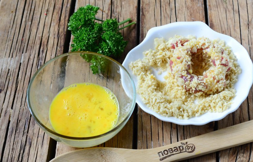 1. Этап. Луковые кольца в беконе и панировке: Чипсы переложите в плотный пакет и завяжите его, с помощью скалки разомните чипсы в крошку – панировка готова. В небольшой пиале взбейте яйцо. Обмакните каждое луковое колечко в беконе сначала в яйцо, а затем в измельченные чипсы.