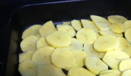 1. Этап. Курица с овощами в духовке: Картошку порезать шайбами. Противень смазать маслом, уложить картошку внахлест. Слегка посолить.