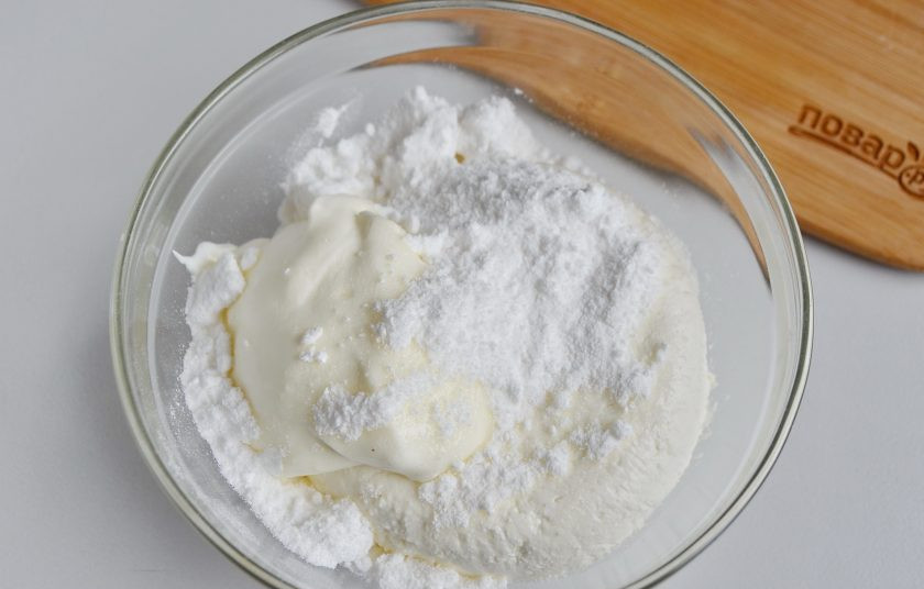 1. Этап. Конфеты Чизкейк в шоколаде: Соедините сливочный сыр и сахарную пудру, добавьте взбитые сливки.