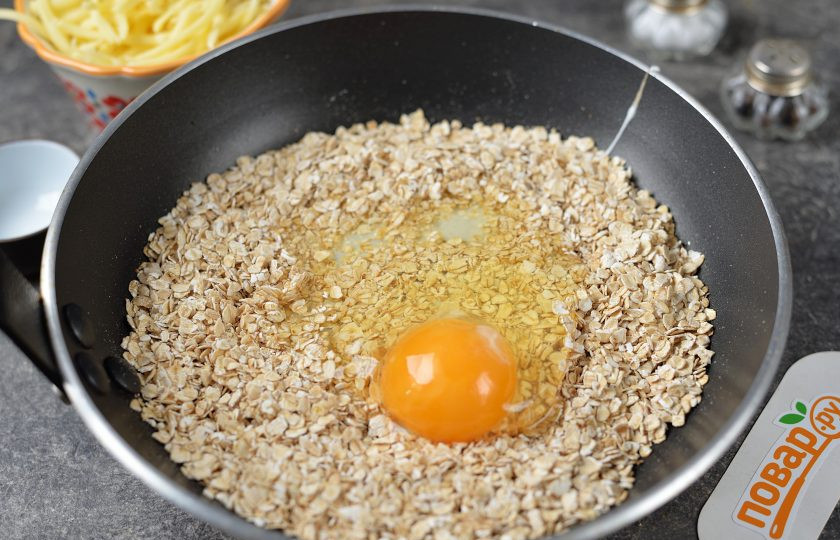 1. Этап. Жареная овсянка с яйцом: Вбейте крупное куриное яйцо, сразу же интенсивно начните смешивать массу до однородности. Огонь уменьшите до минимума.