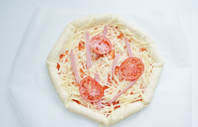 1. Этап. Пицца с сосисками по краям: Смажьте корж соусом (можно использовать томатный соус или кетчуп), присыпьте сыром и выложите начинку.