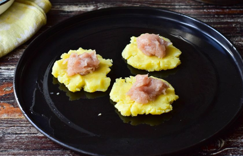 1. Этап. Мясо запеченное в пюре: В центр выложите мясной фарш, в который предварительно добавьте по вкусу соль и перец черный молотый.