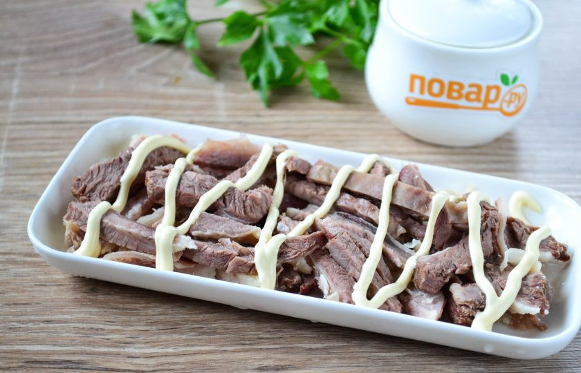 1. Этап. Салат Корель: 2. Говядину нарежьте тонкой соломкой и выложите на дно плоской тарелки. Сверху добавьте майонез.