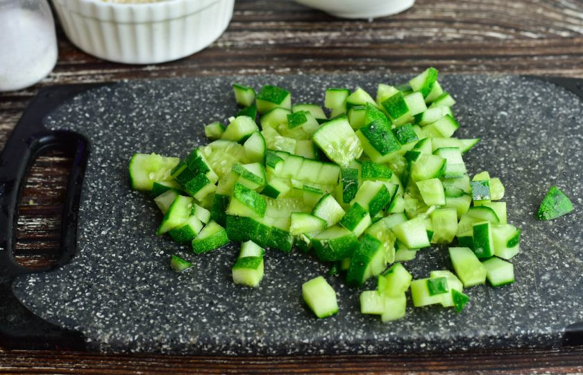 1. Этап. Салат с крабовым мясом по ГОСТу: Свежий огурец вымойте, срежьте края с двух сторон. Нарежьте овощ кубиками.
