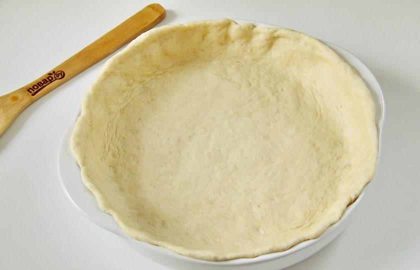 1. Этап. Хуплу: Большую часть теста раскатайте в форме круга толщиной около 5-6 мм, с учетом бортиков около 2-3 см. Перенесите пласт раскатанного теста в смазанную маслом форму.