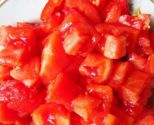 1. Этап. Свинина, тушеная со сливами: 4. Помидоры очищаем от кожицы, для этого делаем крестообразные надрезы сверху и помещаем их в миску, заливаем кипятком и оставляем на 2 минуты, после чего легко снимаем кожицу и нарезаем помидоры крупными кусками.