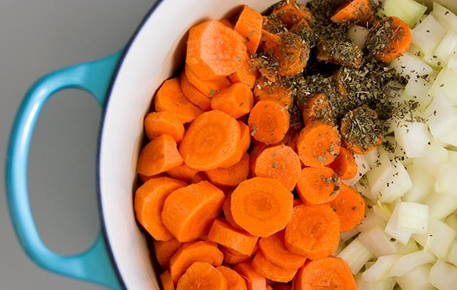 1. Этап. Суп-пюре в блендере: В кастрюлю большую налейте масло оливковое, убедитесь, чтобы не только дно, но и стенки смазались маслом (чтобы овощи не подгорели). Потом добавьте морковку, лук и сушеный базилик. Перемешайте и обжаривайте на среднем огне, пока овощи не подрумянятся - минут 10-12.