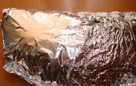 1. Этап. Свинина с чесноком в духовке: 5. Выложить мясо на фольгу и сделать прочный конверт. Сверху проткнуть аккуратно в 2 местах фольгу вилкой или зубочисткой. Края выгнуть так, чтобы сок из мяса не подтекал. Убрать мясо в холодильник на 10-12 часов.