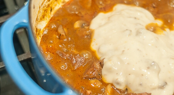 1. Этап. Мясо, тушенное с грибами: 7. Спустя час откройте крышку и влейте сливки, готовьте еще пару минут.