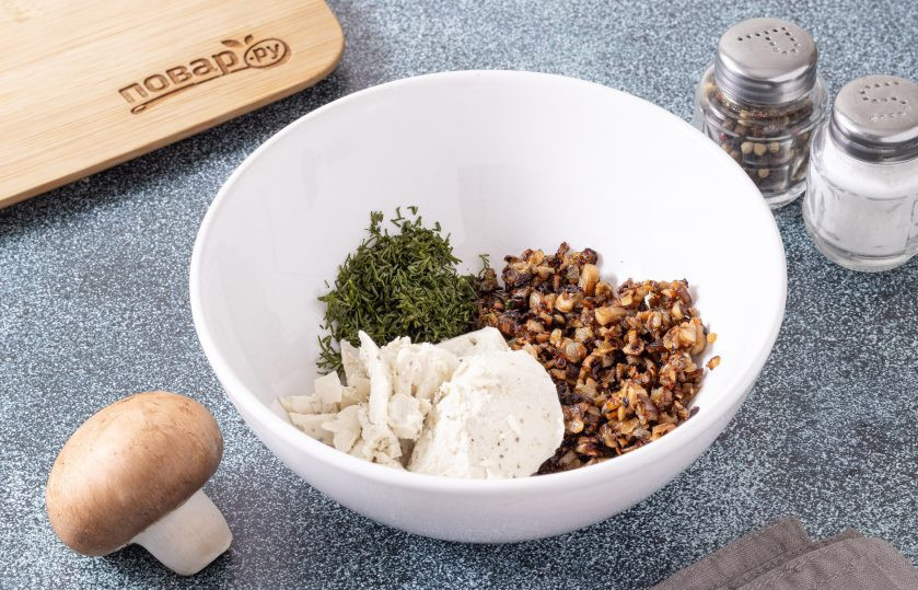 1. Этап. Шампиньоны со сливочным сыром: Смешайте сливочный сыр с жареными ножками и репчатым луком, добавьте измельченную зелень.