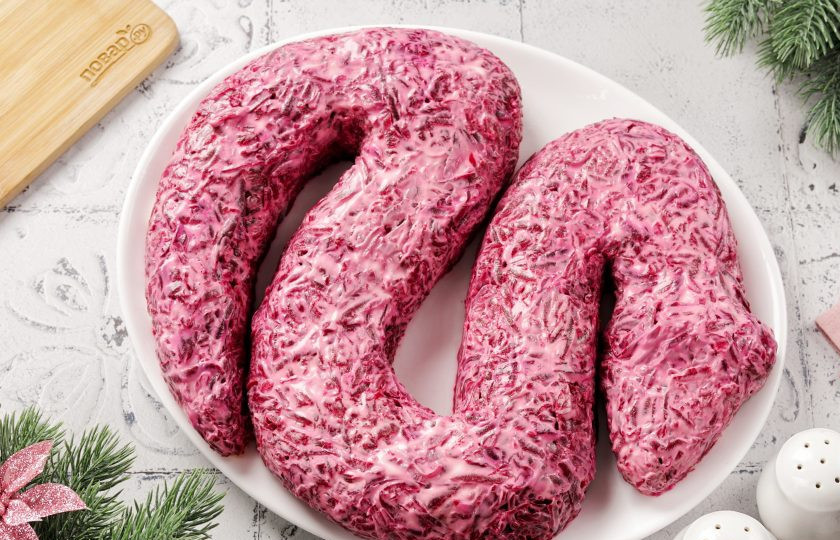 1. Этап. Селедка под шубой на год Змеи 2025: Свеклу посолите и смажьте майонезом, а затем при помощи ложки или небольшой лопатки придайте окончательную форму.