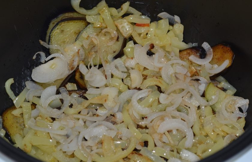 1. Этап. Аджапсандали по-грузински: Лук обжарьте на том же масле, на каком жарили баклажаны. Выложите лук сверху на баклажаны.